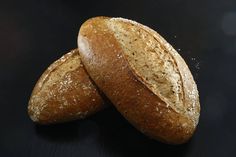 two loaves of bread on a black surface