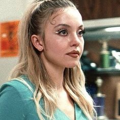 a woman with long blonde hair standing in a kitchen