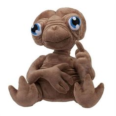 a stuffed animal with big blue eyes sitting on its stomach and giving the peace sign