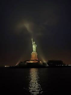 the statue of liberty is lit up at night