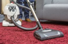 a person is vacuuming the carpet with a machine