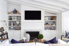 a living room filled with furniture and a flat screen tv mounted on the wall above a fireplace