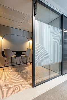 an office with glass walls and chairs