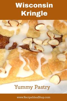 a close up of a pastry on a plate with white icing and almonds