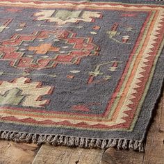 an old rug is laying on the floor with some wood planks in front of it