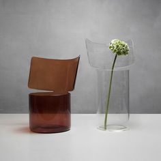 three different colored vases sitting next to each other on a white counter top with a single flower in it