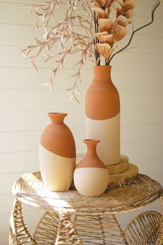 two vases sitting on top of a wicker table