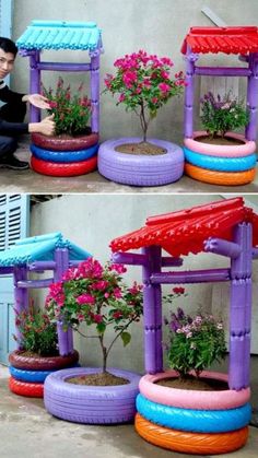 a man sitting on the ground next to some fake flowers and plants in tire tires