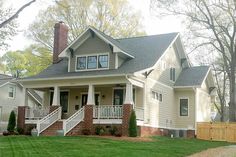 the front of a house with stairs leading up to it's second story and covered porch