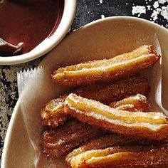 some churros are on a plate with dipping sauce