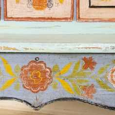 an old painted bench with flowers on it