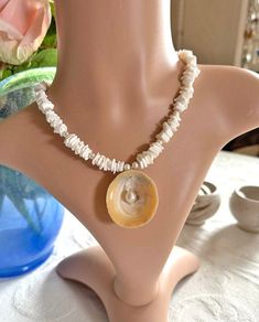 Dive into summer elegance with our exquisite necklace, a harmonious blend of white seashell chips, lustrous white freshwater pearls, and sparkling Charlotte-cut Czech glass beads. At its heart lies a stunning limpet shell adorned with a captivating white freshwater pearl centerpiece. Measuring approximately 40 cm (16 inches) with a 5 cm extension chain, this one-of-a-kind (OOAK) piece captures the allure of the oceanic theme and is perfectly on-trend for the summer of 2024.  Whether you're dress Pearl White Shell With Pearl Charm, White Shell-shaped Shell Jewelry, Mother Of Pearl Shell Strand As Gift, Mother Of Pearl Shell Strand Gift, Elegant White Shell Necklace For Summer, White Round Necklaces For Summer, White Shell-shaped Pearl Drop Necklace, Elegant Beach Pearl Shell Pendant, Elegant Pearl Pendant Shell For Beach