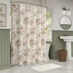 a bath room with a toilet a sink and a shower curtain