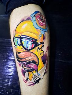 a cartoon character with sunglasses on his face is painted onto the leg of a man