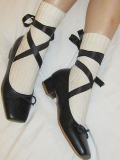 a woman's legs wearing black shoes with white socks and ties on the ankles