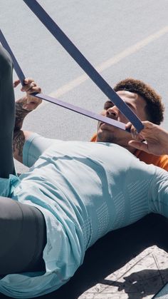 a man is holding two large scissors in his hands while laying down on the ground