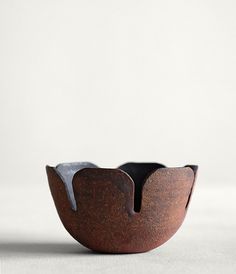 a brown bowl sitting on top of a white table