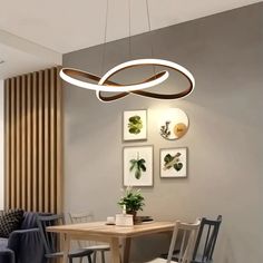 a dining room table with chairs and a light fixture hanging from it's ceiling