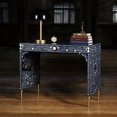 a desk with books and a clock on it sitting in front of a window at night