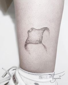 a black and white photo of a small stingfish tattoo on the right thigh, with dots all over it