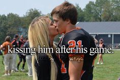 a couple kissing each other in front of a football field with the words kissing him after his game