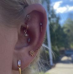 a close up of a person's ear with three different piercings on it