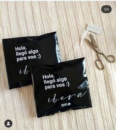 two black bags sitting on top of a bed next to scissors