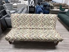 a living room filled with lots of couches and chairs next to each other on top of a hard wood floor