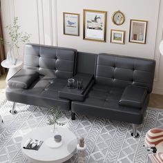 a black leather couch sitting on top of a white rug