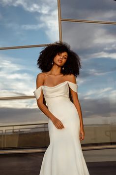 a woman in a white dress posing for the camera