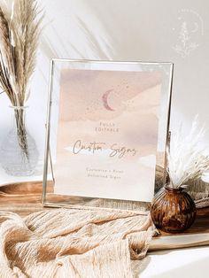 a glass frame sitting on top of a table next to some dried grass and other items