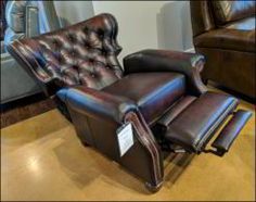 a leather recliner chair and ottoman in a showroom