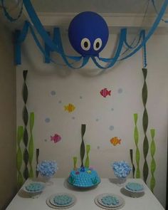 an octopus themed birthday party with cupcakes and cake on the table in front of it