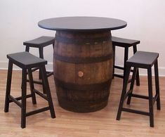 three stools and a table made out of wine barrels