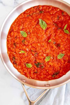 a pan filled with tomato sauce on top of a table