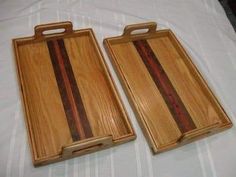 two wooden trays sitting on top of a bed