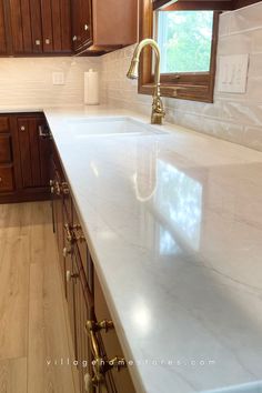 a kitchen with white counter tops and wooden cabinets