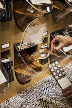 a person holding a piece of food in front of a display case filled with items