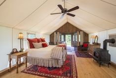 a bed sitting inside of a bedroom on top of a wooden floor next to a fire place