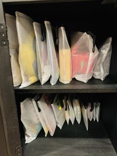 several mesh bags are stacked on top of each other in front of a metal shelf