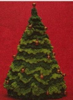 a small green christmas tree sitting on top of a red floor