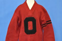 Chest 18 in.Length 25 in. Sleeve 20 in. Tag Says: LThis v-neck letterman sweater is from the 1940s!  It is red with black stripes on the left sleeve and a large "O" applique on the front.  The sweater is very old and some of the yarn is partially unraveled, though there are not any explicit holes that we can find.Comments: Fits like a modern unisex adult small, waistband is very small. The sweater is very old and some of the yarn is partially unraveled, though there are not any explicit holes th Vintage Sweater For College In Winter, Vintage Winter Sweater For College, Vintage College Sweater For Fall, Vintage Solid Color Sweater For Fall, Vintage Solid Sweater For Fall, Solid Vintage Sweater For Fall, Collegiate Red Sweater For Fall, Retro Sweater For College In Fall, Vintage Sweater For College In Fall