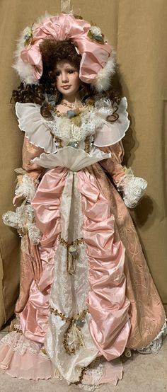 "Beautiful 34\" Victorian-style doll from Cathay Collection, No. 15000.  Head and shoulders, arms and legs are made of hard plastic.  Torso is cloth.  Dress is made of satin layered with lace, beads and taffeta. Shoes are painted on.  Hair is shiny and curly. Hazel eyes are made of glass with lashes attached (lashes on left eye are downward).  She wears a fancy lace and feather hat and a pink beaded necklace. Doll is in pristine vintage condition.  Dress does show some small stains consistent with age.  Does not come with stand or box." Pink Beaded Necklace, Head And Shoulders, Left Eye, Victorian Dolls, Feather Hat, Cloth Dress, Head & Shoulders, Hazel Eyes, Miniature Art