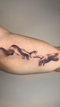 the creation of man's hands is depicted in this tattoo on the left arm