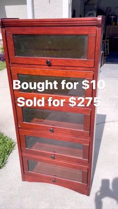 a red wooden cabinet sitting on top of a sidewalk next to a building with the words bought for $ 10 sold for $ 27