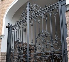 an iron gate is shown in front of a brick building