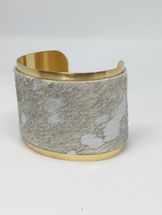 A striking and unique statement bracelet, you are sure to love this piece. Made using the finest quality hair on leather with striking metallic silver accents on a brass cuff. The cuff measures 2 inches wide and is adjustable. Gold Leather Cuff Bracelet For Formal Occasions, Elegant Leather Cuff Bracelet For Party, Formal Gold Leather Cuff Bracelet, Gold Leather Cuff Bracelet, Unique Handmade Gold Leather Bracelet, Unique Gold Handmade Leather Bracelet, Silver Leather Cuff Jewelry, Luxury Leather Cuff Jewelry, Chic Silver Leather Jewelry