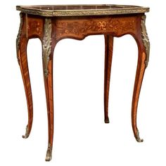 an antique wooden table with marble top and drawers on one side, inlaid to the other