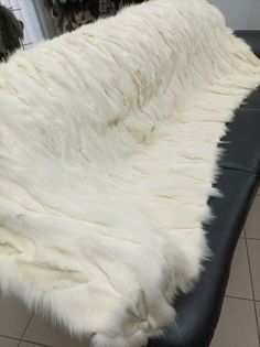 a large white fur covered bench in a store