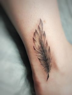 a small feather tattoo on the ankle